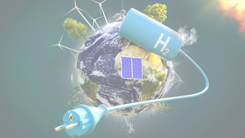 Windräder, Photovoltaik und ein Wasserstofftank auf einer Weltkugel mit Bäumen