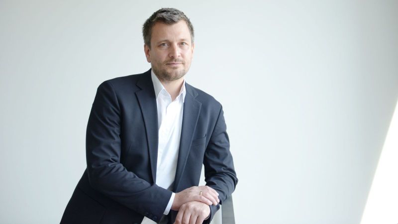 Boris Linden, Geschäftsführer Neuland Hambach, steht vor einer weißen Wand