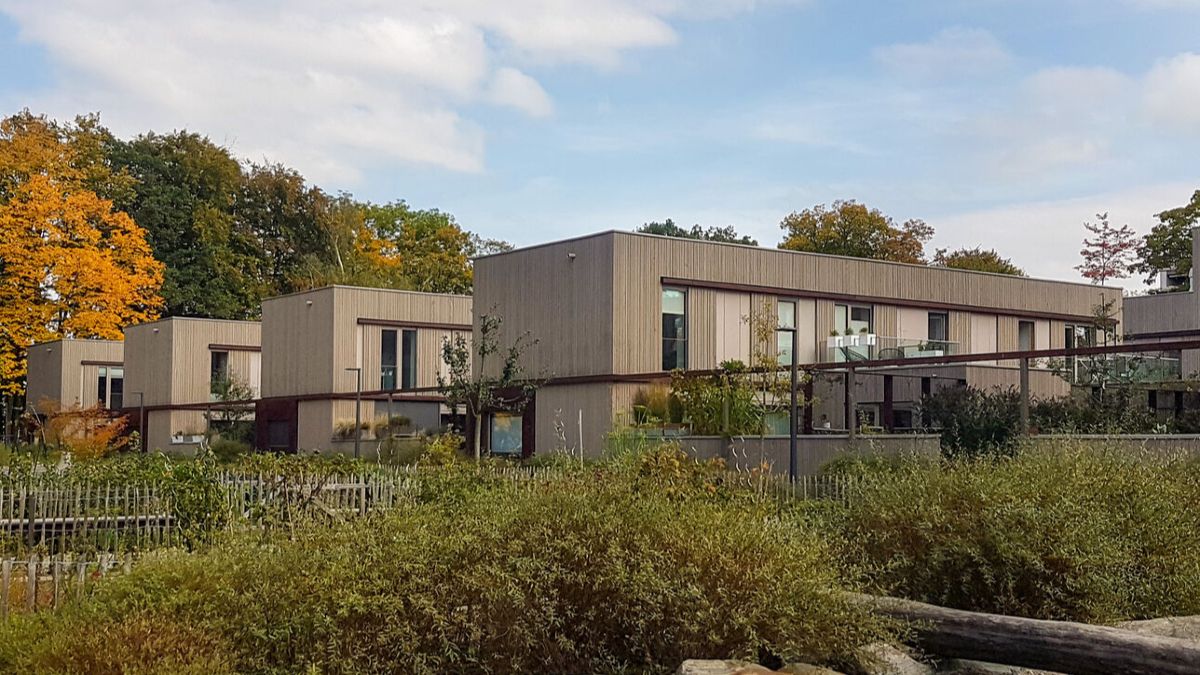 Reihen ökologisch gebauter Musterhäuser in München mit Garten davor